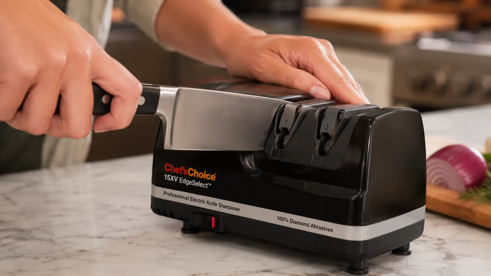 A hand pressing a wide-bolstered chef's knife into the Chef'sChoice angle guide slot with the heel of the blade not sitting fully flush