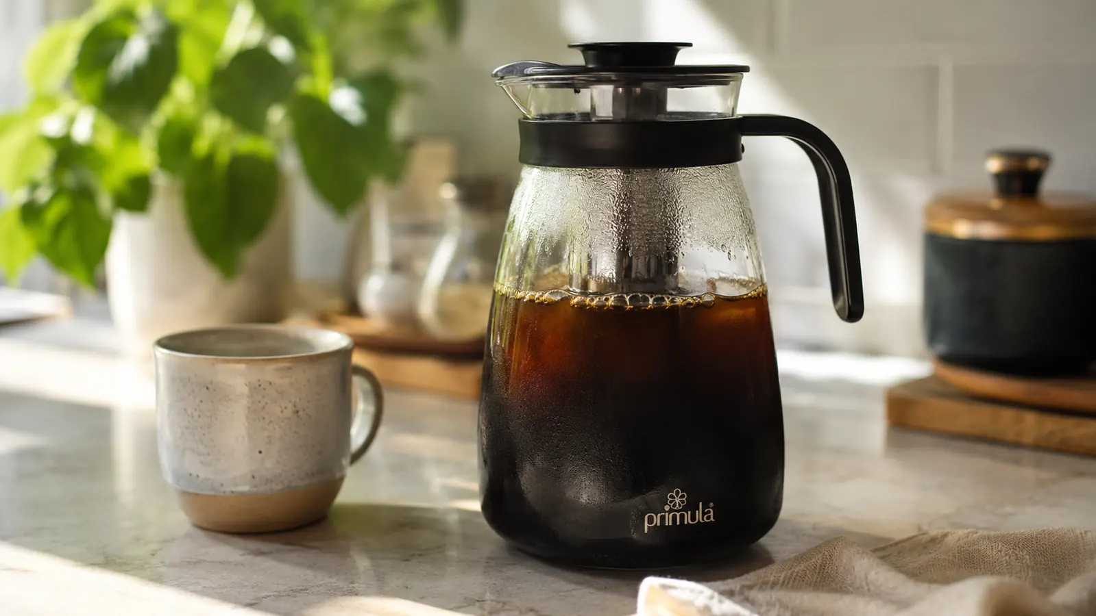 Glass Primula cold brew carafe sitting on a kitchen counter in morning light
